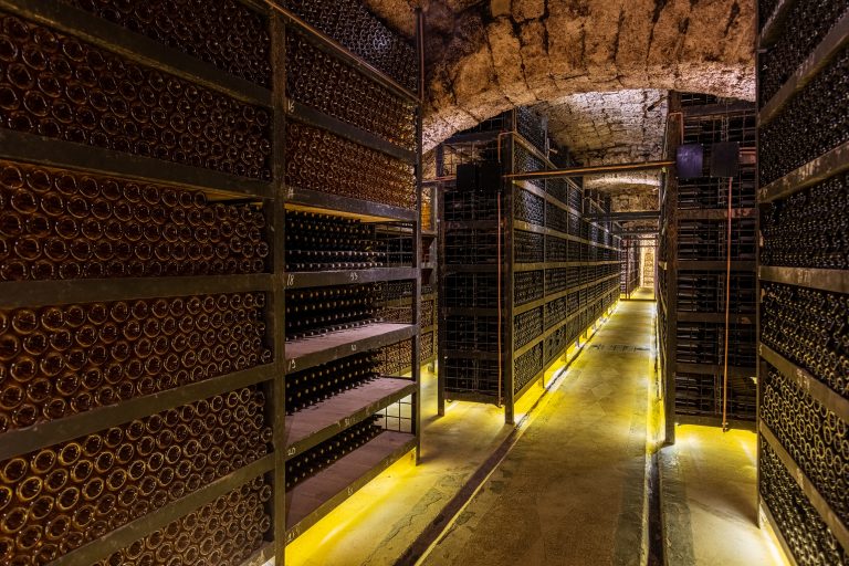 Rafturi cu sticle de vin în Beciul Domnesc