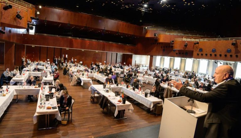 Juriul internațional degustând vinuri la competiția Mundus Vini, într-o sală plină de specialiști din întreaga lume.