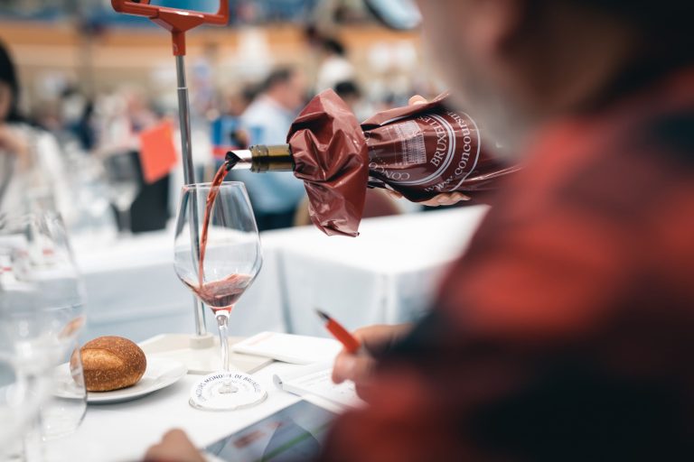Turnare de vin roșu într-un pahar în cadrul Concours Mondial de Bruxelles, degustare în orb.